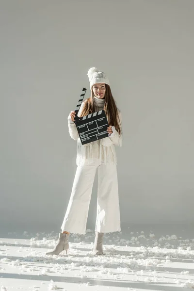 Attractive Woman Fashionable Winter Sweater Scarf Holding Clapper Board White — Stock Photo, Image