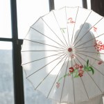 Sylwetka kobiety stojącej z papier parasol w pobliżu okna