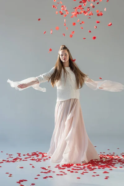 Приваблива Жінка Модному Зимовому Вбранні Кружляє Під Падаючими Червоними Трояндами — стокове фото