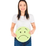 Attractive girl holding green sign with sad face expression while looking at camera isolated on white