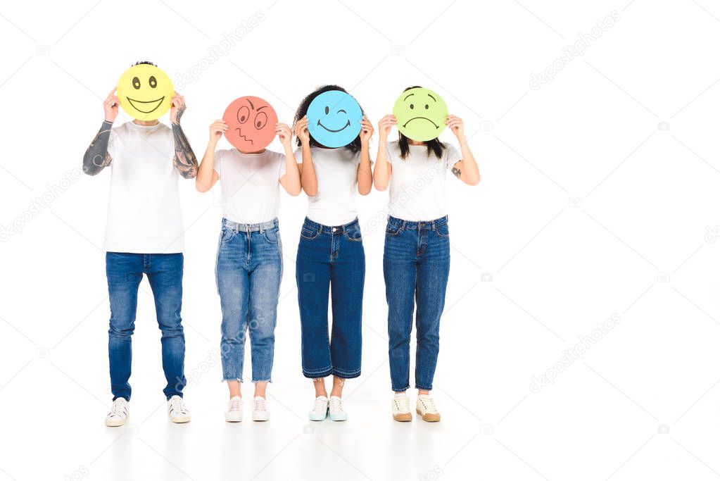 multicultural friends holding round, multicolored signs with different face expressions isolated on white