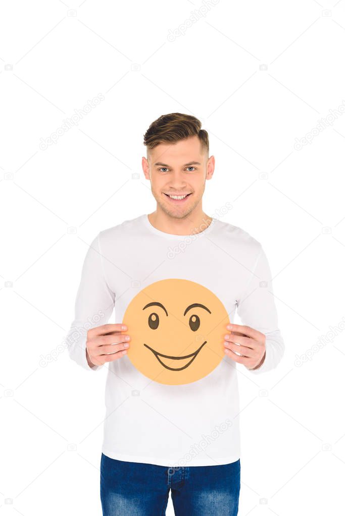 handsome man holding round yellow card with cunning face expression isolated on white