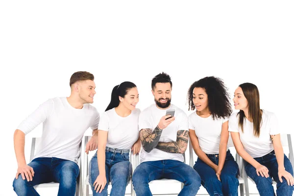 Uomo Tatuato Sorridente Utilizzando Smartphone Mentre Giovani Curiosi Multietnici Guardando — Foto Stock