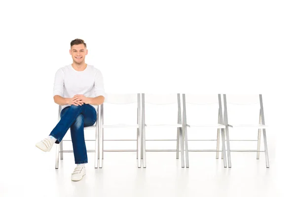 Schöner Junger Mann Sitzt Mit Überkreuzten Beinen Isoliert Auf Weiß — kostenloses Stockfoto