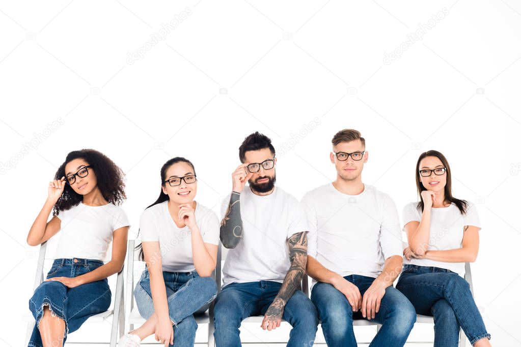 multicultural group of young people in glasses looking at camera isolated on white