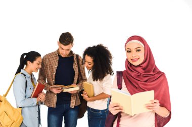 kitap çok ırklı bir grup genç insan üzerinde beyaz izole yakınındaki ile duran Müslüman kadın 