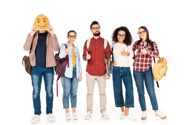 milticultural group of people in glasses showing thumbs up and standing with man showing happy emotion on card isolated on white