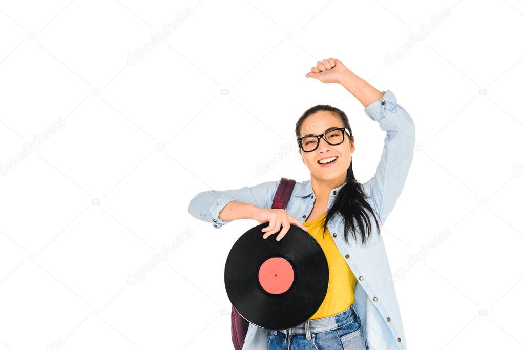 happy girl in glasses holding vinyl record with hand above head isolated on white