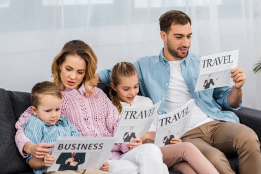 Aile kanepede oturan ve oturma odasında seyahat ve iş gazete okuma