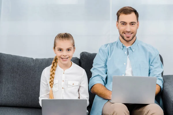 Smiling Daughter Father Sitting Sofa Holding Laptops Looking Camera Living — Stock Photo, Image