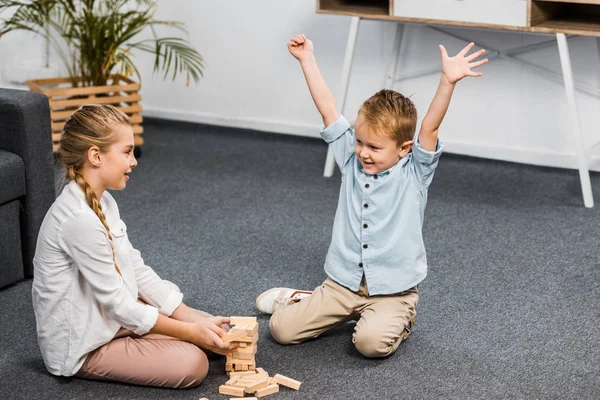 Happy Boy Raising Hands Cute Girl Sitting Floor Playing Blocks — Stock Photo, Image