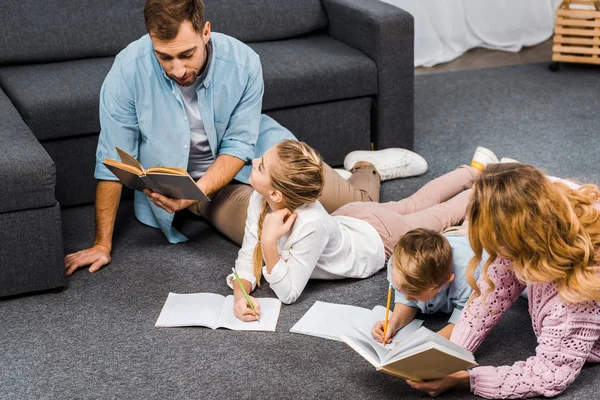 Padres Leyendo Libros Mientras Los Niños Escriben Cuadernos Piso Apartamento — Foto de Stock