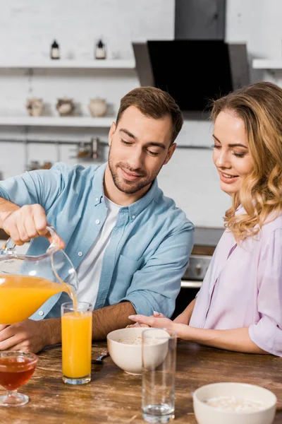 Smiling Man Pouring Orange Juice Glass Pretty Wife — Stock Photo, Image