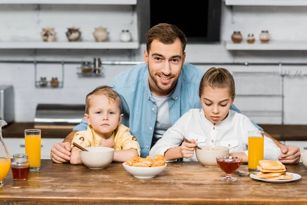 Smiling Father Looking Camera Embracing Siblings Eating Porridge Table — Free Stock Photo
