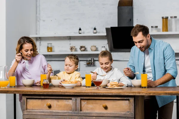 キッチンのテーブルでお粥を食べて幸せな家族  — 無料ストックフォト