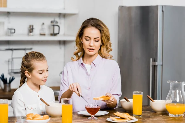 Mulher Bonita Espalhando Geléia Torradas Para Filha Cozinha — Fotografia de Stock