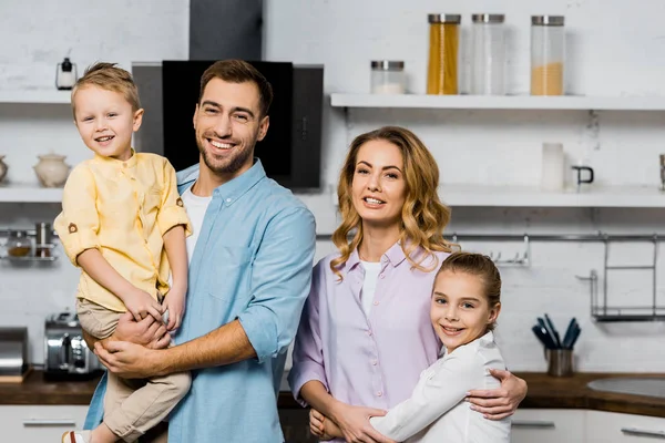 Handsome Man Holding Son Pretty Mother Embracing Cute Daughter Kitchen — Stock Photo, Image