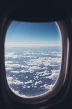 Uçak penceresinden mavi bulutlu gökyüzü görünümü