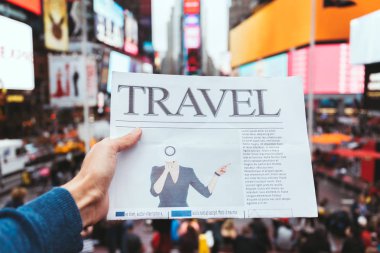 partial view of man holding business newspaper with blurry new york city street view on background clipart