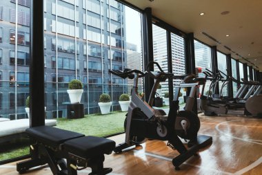 close up view of exercise equipment in gym and flowerpots on balcony clipart