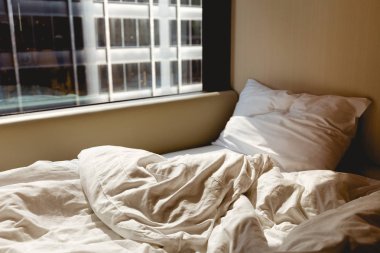 otel odasında pencere yakınındaki boş yatak görünümünü kapat