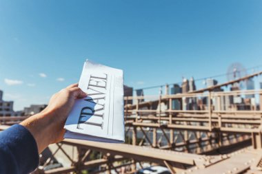 bir arka plan üzerinde bulanık new york city Köprüsü manzaralı seyahat gazete tutan adam kısmi görünümü