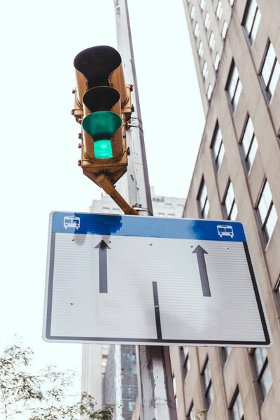 urban scene with buildings, traffic light and road sign in new york city, usa
