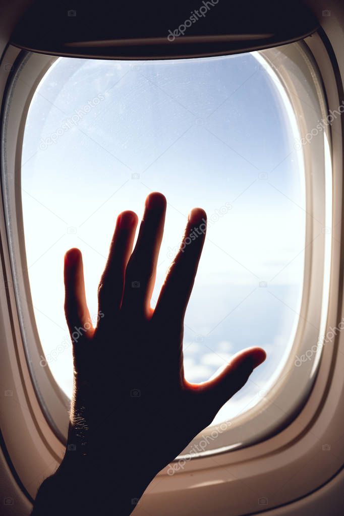 partial view of man in airplane and blue cloudy sky 