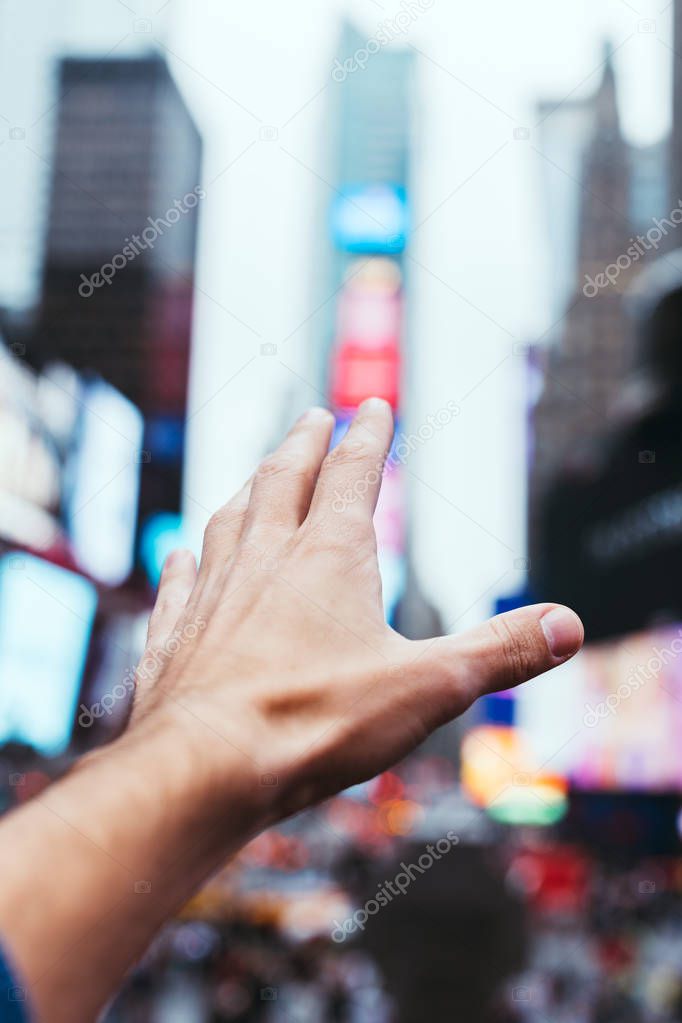 partial view of male hand and blurry new york city street on background