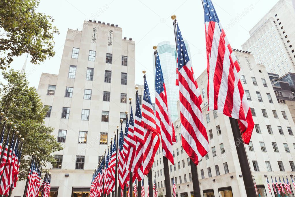 low angle view of american flags and buildings, new york, usa