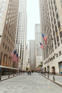 NEW YORK, USA - OCTOBER 8, 2018: low angle view of skyscrapers and citizens on street, new york, usa clipart