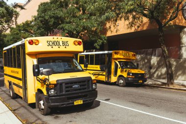 NEW YORK, USA - OCTOBER 8, 2018: yellow school buses parked on street, new york, usa clipart