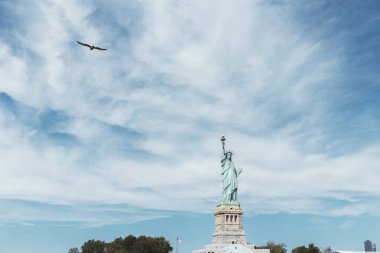 STATUE OF LIBERTY, NEW YORK, USA - OCTOBER 8, 2018: statue of liberty in new york against blue cloudy sky background, usa clipart