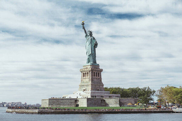 STATUE OF LIBERTY, NEW YORK, USA - 8 октября 2018 года: статуя свободы в Нью-Йорке на фоне голубого облачного неба, США
