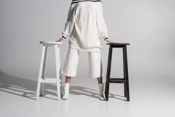 Imagen Recortada Chica Suéter Moda Pantalones Pie Entre Las Sillas —  Fotos de Stock