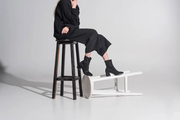 Abgeschnittenes Bild Einer Frau Schwarzer Kleidung Die Auf Einem Stuhl — kostenloses Stockfoto