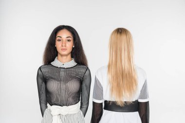 duran siyah beyaz giysili güzel çok kültürlü kadınlar üzerinde beyaz izole