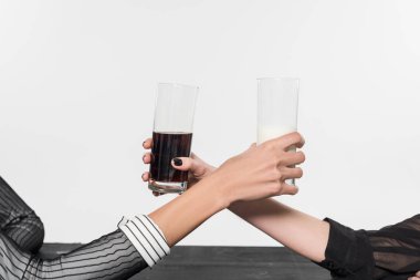 siyah ve beyaz giysili süt ve üzerinde beyaz izole soda ile gözlük tutan çekici çok ırklı kadınların kırpılmış görüntü