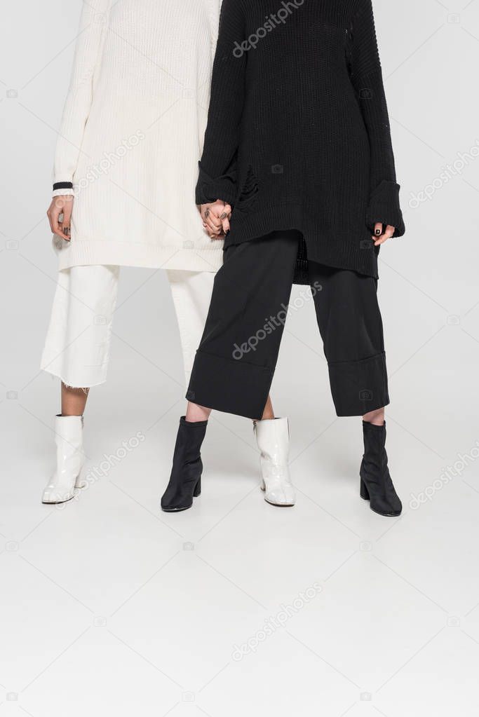 low section of multicultural women in black and white clothes standing on white