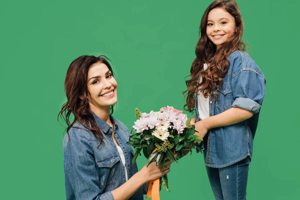 mutlu anne ve kızı çiçekli yeşil izole kamera bakıyor