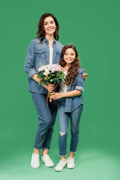 Happy Mother Daughter Denim Holding Flowers Looking Camera Green Background — Stock Photo, Image