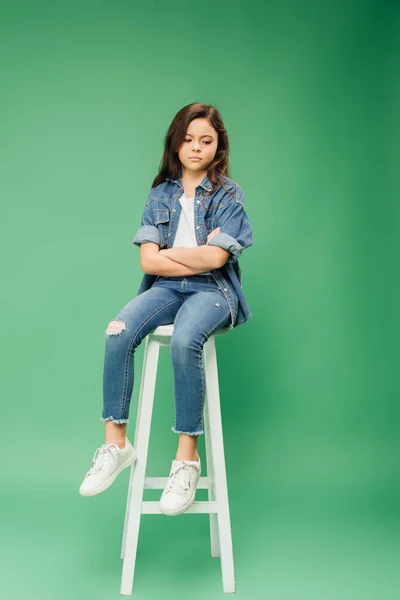 Sad Child Denim Sitting Chair Arms Crossed Green Background — Stock Photo, Image