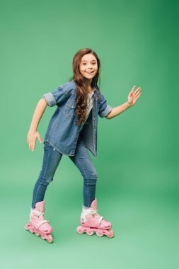 yeşil arka plan üzerinde uzanmış ile gülümseyen çocuk paten eller