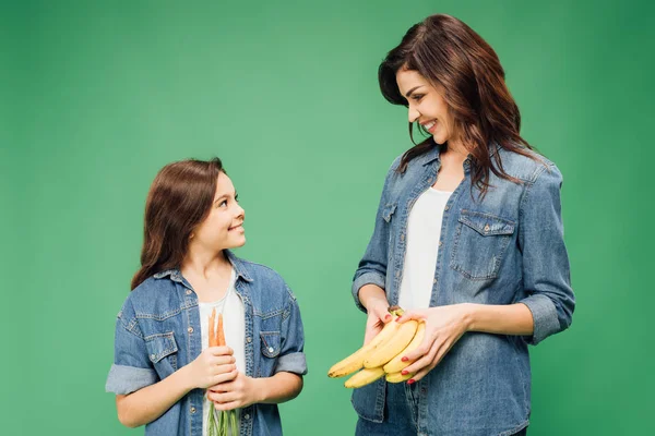 Madre Figlia Sorridente Che Tengono Banane Carote Isolate Sul Verde — Foto Stock