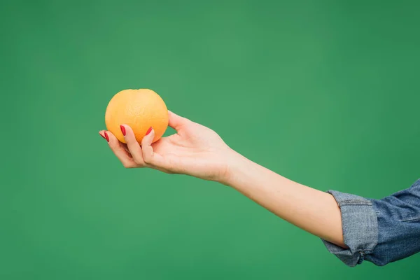 Περικοπεί Δείτε Γυναίκα Κρατώντας Πορτοκάλι Στο Χέρι Απομονωμένη Στο Πράσινο — Φωτογραφία Αρχείου