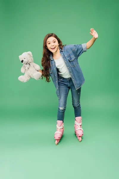 Child Rollerblading Outstretched Hands Teddy Bear Green Background — Stock Photo, Image