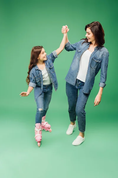 Lycklig Dotter Rullskridskor Hålla Händer Och Jublar Med Mamma Grön — Stockfoto