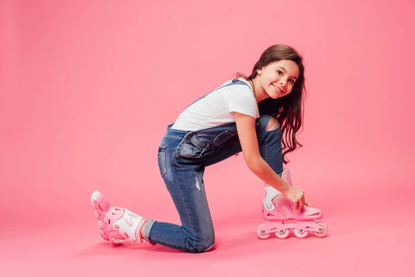 Cute Child Overalls Putting Rollerblades Pink Background — Stock Photo, Image