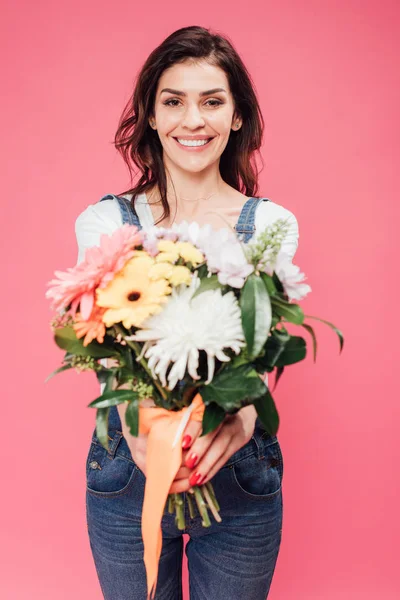微笑的妇女拿着花束的选择性焦点查出在粉红色 — 图库照片