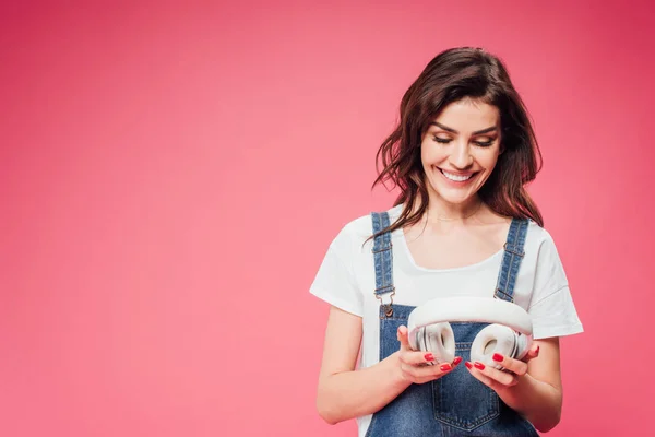 Belle Femme Tenant Des Écouteurs Isolés Sur Rose — Photo